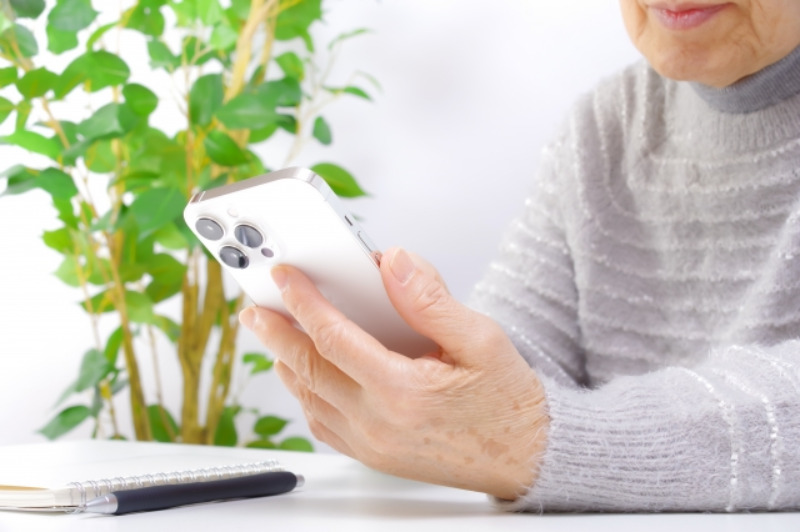 スマホを見る高齢女性のイメージ