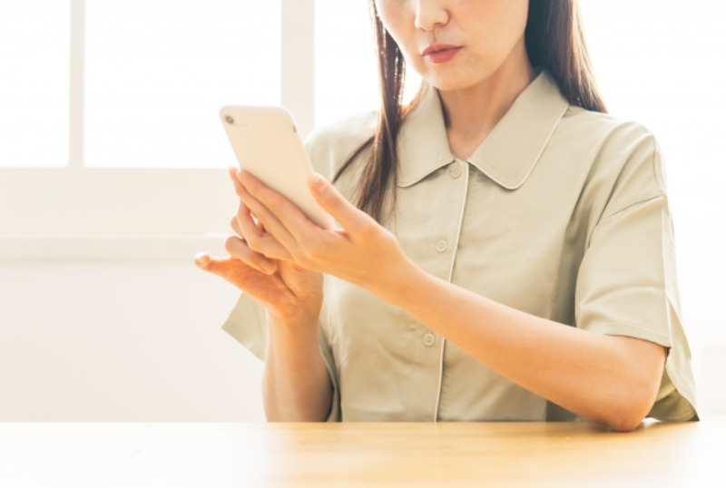 スマホを見て困っている女性のイメージ