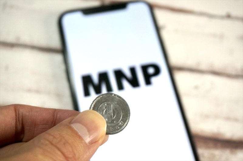 1円玉を持つ手元とMNPと表示されたスマートフォン